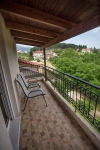 een balkon met een bank en uitzicht op de bomen bij Όμορφη σοφίτα 5λεπτά από το κέντρο της πόλης in Ioannina