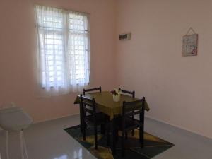 a table and chairs in a room with a window at UMMI'S Homestay Besut in Kuala Besut