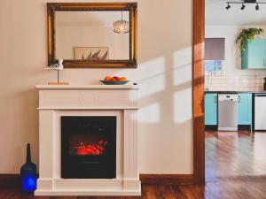 a living room with a fireplace and a mirror at Rose Court Apartments "Astera" in New Town