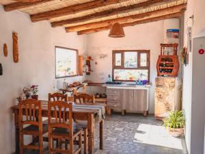 La cuisine est équipée d'une table, de chaises et d'un réfrigérateur. dans l'établissement Cabaña Paraíso Cachi, à Cachí