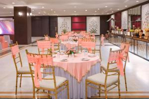 un salón de banquetes con mesas y sillas rosas en Shree Vallabh Vilas Lords Plaza, en Eklingji
