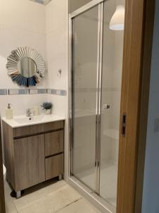a bathroom with a shower and a sink and a mirror at Charming Cozy Retreat - Terrace & Private Balcony in Coimbra