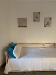 1 cama en un dormitorio con 2 cuadros en la pared en Deluxe Studio com terraço e varanda privada - 'Casinha da Amoreira' Guesthouse, en Coímbra