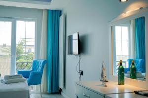 a blue room with a bed and a tv and a mirror at NOVA PORT Boutique Hotel in Tekirdağ