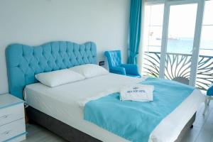 a bedroom with a large bed with a blue headboard at NOVA PORT Boutique Hotel in Tekirdağ