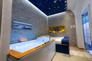 a bathroom with a large bath tub next to a bed at Stabiae Luxury Room in Castellammare di Stabia