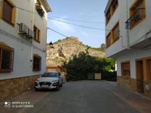 un coche aparcado en un aparcamiento entre dos edificios en Apartamento Nerpio, en Nerpio