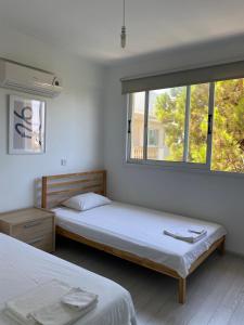 1 Schlafzimmer mit 2 Betten und einem Fenster in der Unterkunft Home away from Home in Paphos City