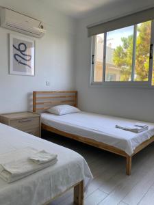 2 Betten in einem Zimmer mit Fenster in der Unterkunft Home away from Home in Paphos City