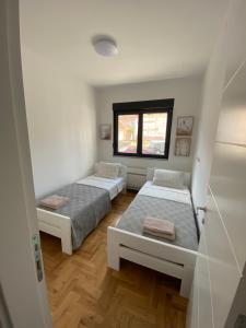 1 dormitorio con 2 camas y ventana en Amfora Suite, en Trebinje