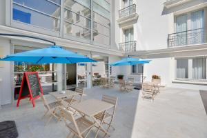 a patio with tables and chairs and umbrellas at Best Western Hôtel Journel Antibes Juan-les-Pins in Antibes