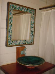 baño con lavabo verde y espejo en Bungalow Karaib Lodge, en Saint-François