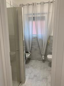 a bathroom with a toilet and a sink and a window at Appartamento SanBart Mare in San Bartolomeo al Mare