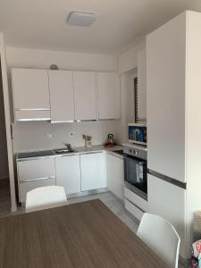 uma cozinha com armários brancos e electrodomésticos brancos em Appartamento SanBart Mare em San Bartolomeo al Mare