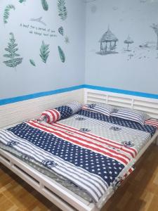2 camas en una habitación con colcha de bandera americana en NHÀ NGHỈ BẾN TÀU 1, en Rạch Giá