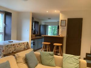 a living room with a couch and a kitchen at La petite maison terre mer in Plélo