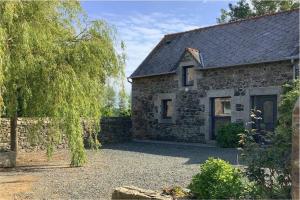 an old stone house with a driveway in front of it at La petite maison terre mer in Plélo