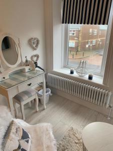 a bathroom with a vanity and a mirror and a window at Coastal Joy - Family and friends bedrooms in Newbiggin-by-the-Sea