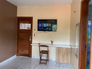 a kitchen with a bar with a television on the wall at Pedra do Sol Pousada in Alter do Chao