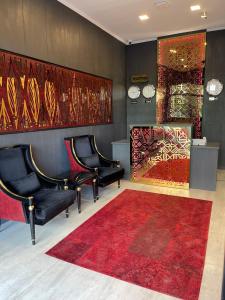 a waiting room with two chairs and a red rug at Denis hotel in Tbilisi City
