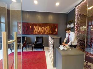 Denis hotel في تبليسي: رجل يجلس في مكتب في الردهة