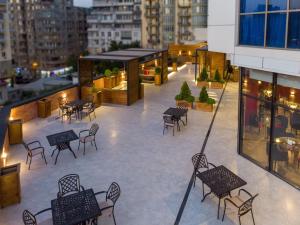 patio ze stołami i krzesłami w budynku w obiekcie Denis hotel w mieście Tbilisi City