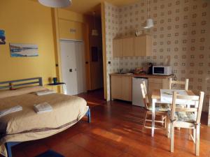 a bedroom with a bed and a table and a kitchen at Leucosia Bed & Breakfast in Salerno +13 photos