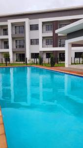 a large swimming pool in front of a building at Sarona city Habitat Alpha apartments C202 Gaborone in Gaborone