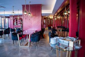 restauracja z czerwonymi ścianami, stołami i krzesłami w obiekcie Denis hotel w mieście Tbilisi City