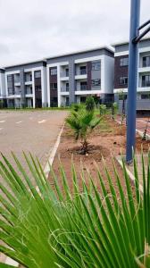 um grande edifício com um parque de estacionamento em frente em Sarona city Habitat Alpha apartments C202 Gaborone em Gaborone