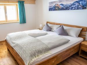 ein Bett mit weißer Bettwäsche und Kissen in einem Schlafzimmer in der Unterkunft Ferienwohnung Schwendle Egg in Mittelberg