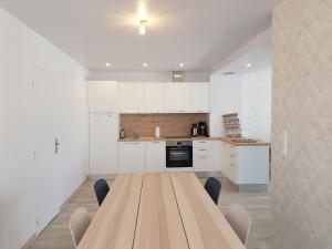 een keuken met een houten tafel met stoelen erin bij COTE JARDIN - CANCALE - GITE STANDING - PROCHE CENTRE ET PORT in Cancale