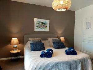 Un dormitorio con una cama con almohadas azules. en Les Jardins d'Eleusis, en Murs