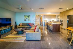 a living room with a couch and a kitchen at ZEN AT ONE30: 3-BR Luxury Corporate Long Stays in Darwin