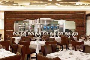 un ristorante con tavoli bianchi e sedie marroni di Aspen St Regis Resort Hotel Room With 2 Queens ad Aspen