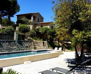 a house with a swimming pool in front of a house at Le Bastion des Papes in Châteauneuf-de-Gadagne