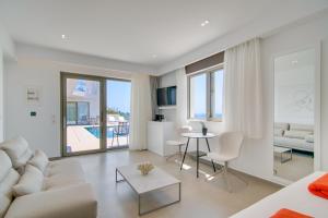 a white living room with a couch and a table at LIVINGHOME SUITES in Parga