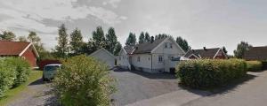 una casa blanca con un coche aparcado en una entrada en Krokenskogen, en Sandefjord