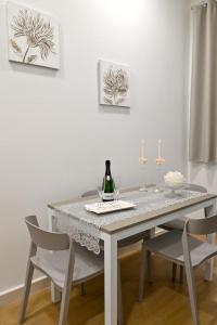 a dining room table with two chairs and a bottle of wine at Floris Pompei in Pompei