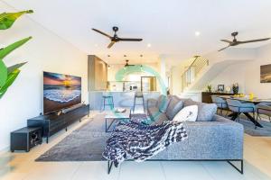 sala de estar con sofá azul y cocina en ZEN ARCTIC Luxury 2-Story T/House + Pool & Markets, en Fannie Bay