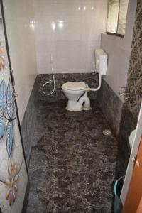 a bathroom with a white toilet in a room at Hotel Gokarn Lodging in Satara