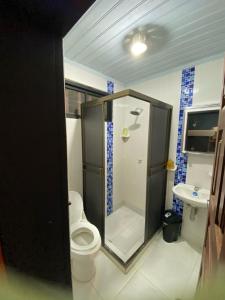 uma casa de banho com um chuveiro, um WC e um lavatório. em Tambo Hostel em Letícia