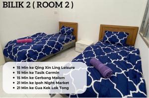- une chambre avec 2 lits et une couette bleue et blanche dans l'établissement TAG Homestay Classic IPOH, à Lahat