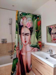 a bathroom with a shower curtain of a woman with flowers at Les Jardins d'Eleusis in Murs