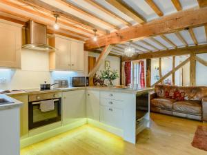 a kitchen and living room with a couch at 16th Century Cartlodge with private hot tub in Diss