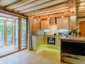 a kitchen with wooden ceilings and a large window at 16th Century Cartlodge with private hot tub in Diss