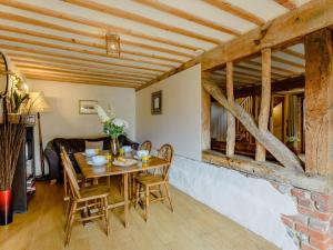 a dining room with a table and chairs at 16th Century Cartlodge with private hot tub in Diss