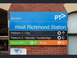 a sign for the west rutherford station on a brick wall at Richmond Private Rooms - 151 Hoddle Homestay in Melbourne