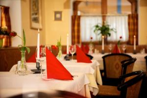 a group of tables with red napkins on them at Hotel Grafenwirt in Wagrain