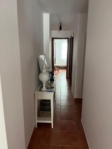 a hallway with a table with a lamp on it at Apartamento Ophelia in Puerto del Rosario